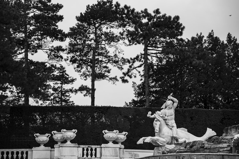 una foto in bianco e nero di una donna seduta su una fontana