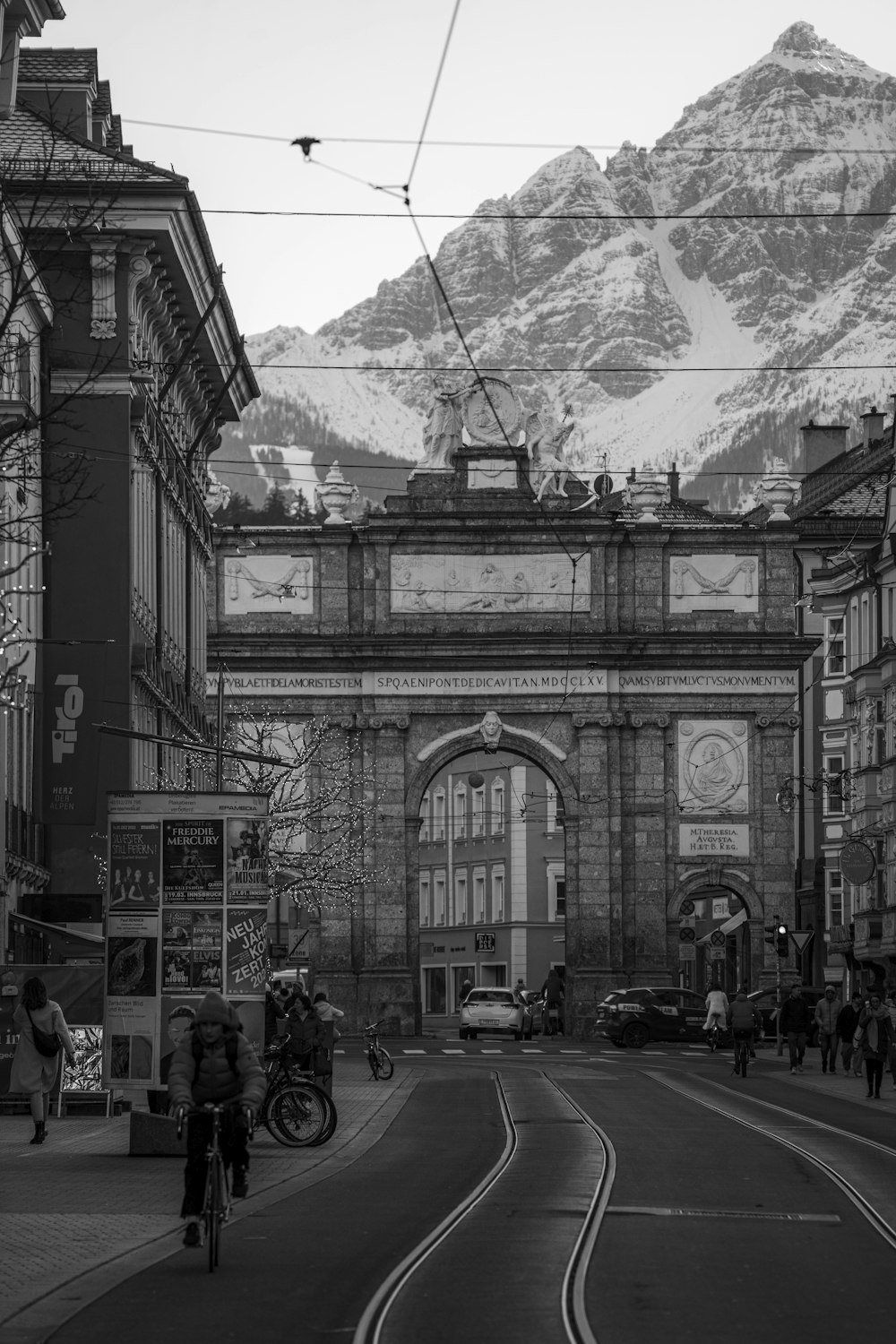 a black and white photo of a street with a mountain in the background