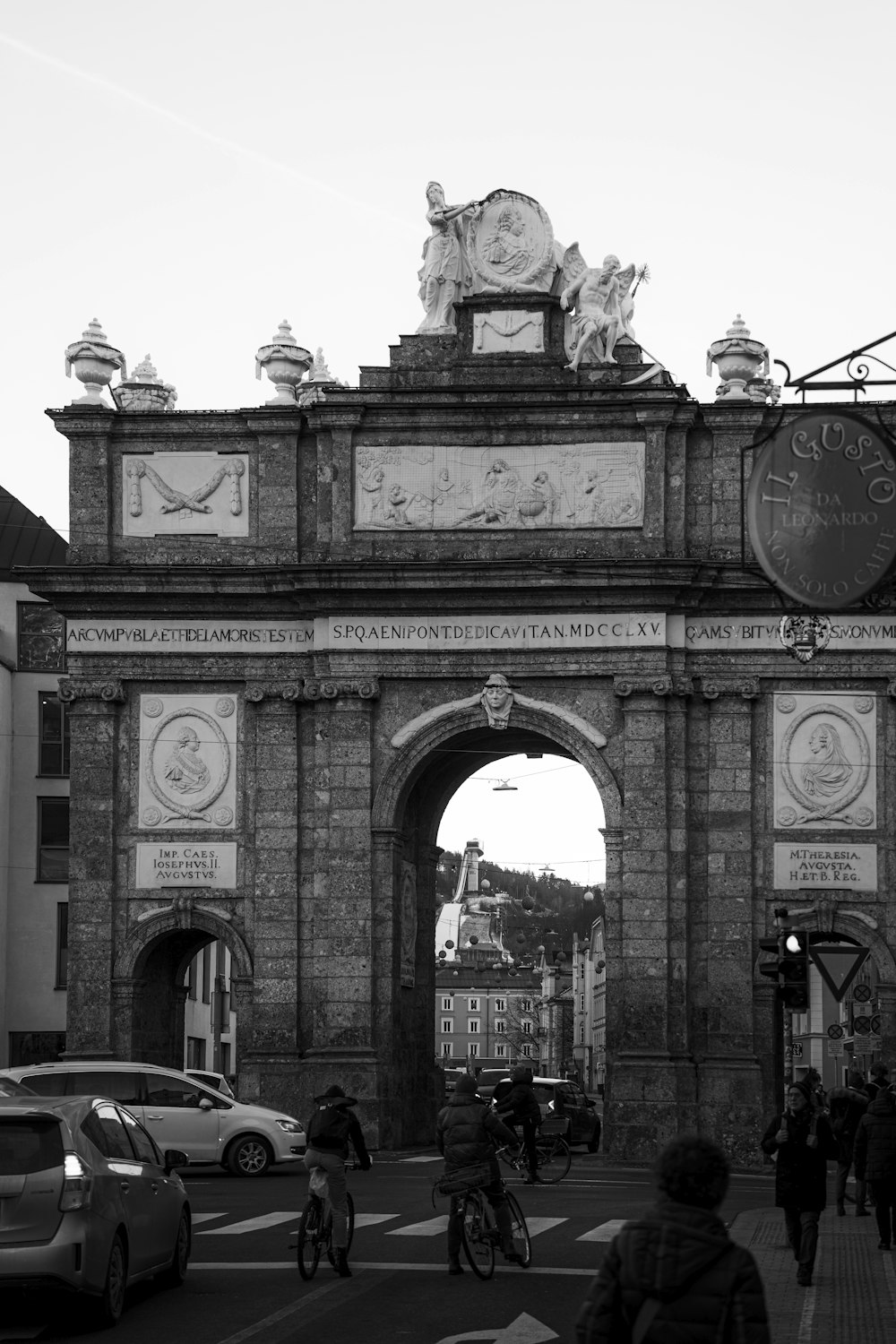 a black and white photo of a city gate