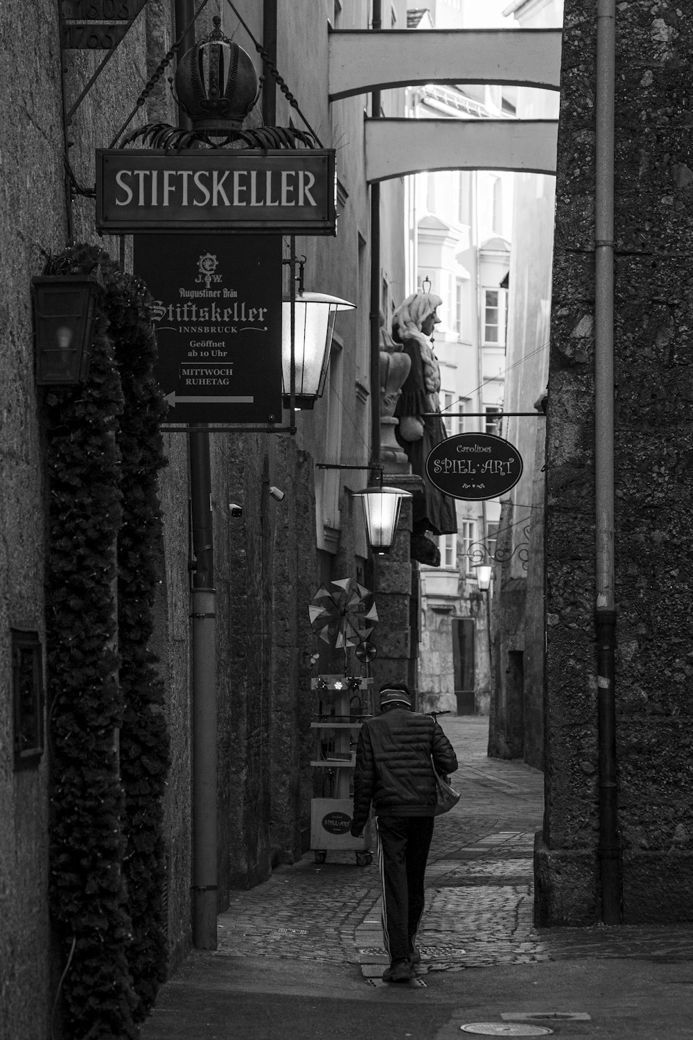 a black and white photo of a person walking down a street