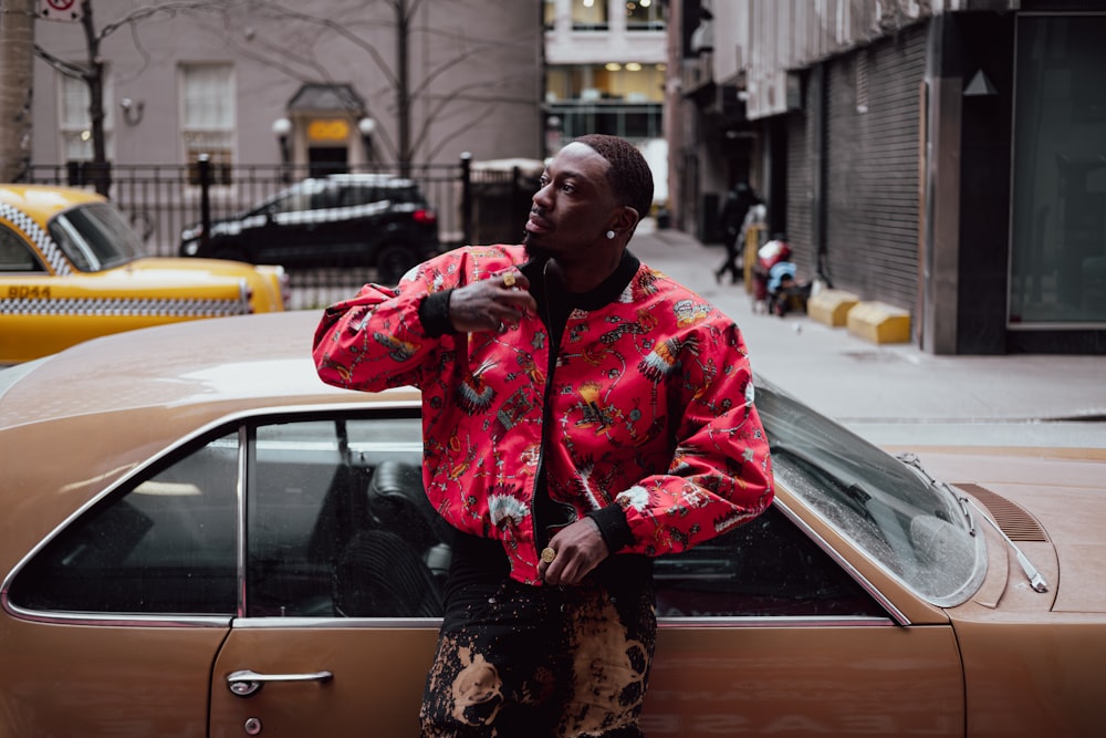 a man standing next to a car on a city street