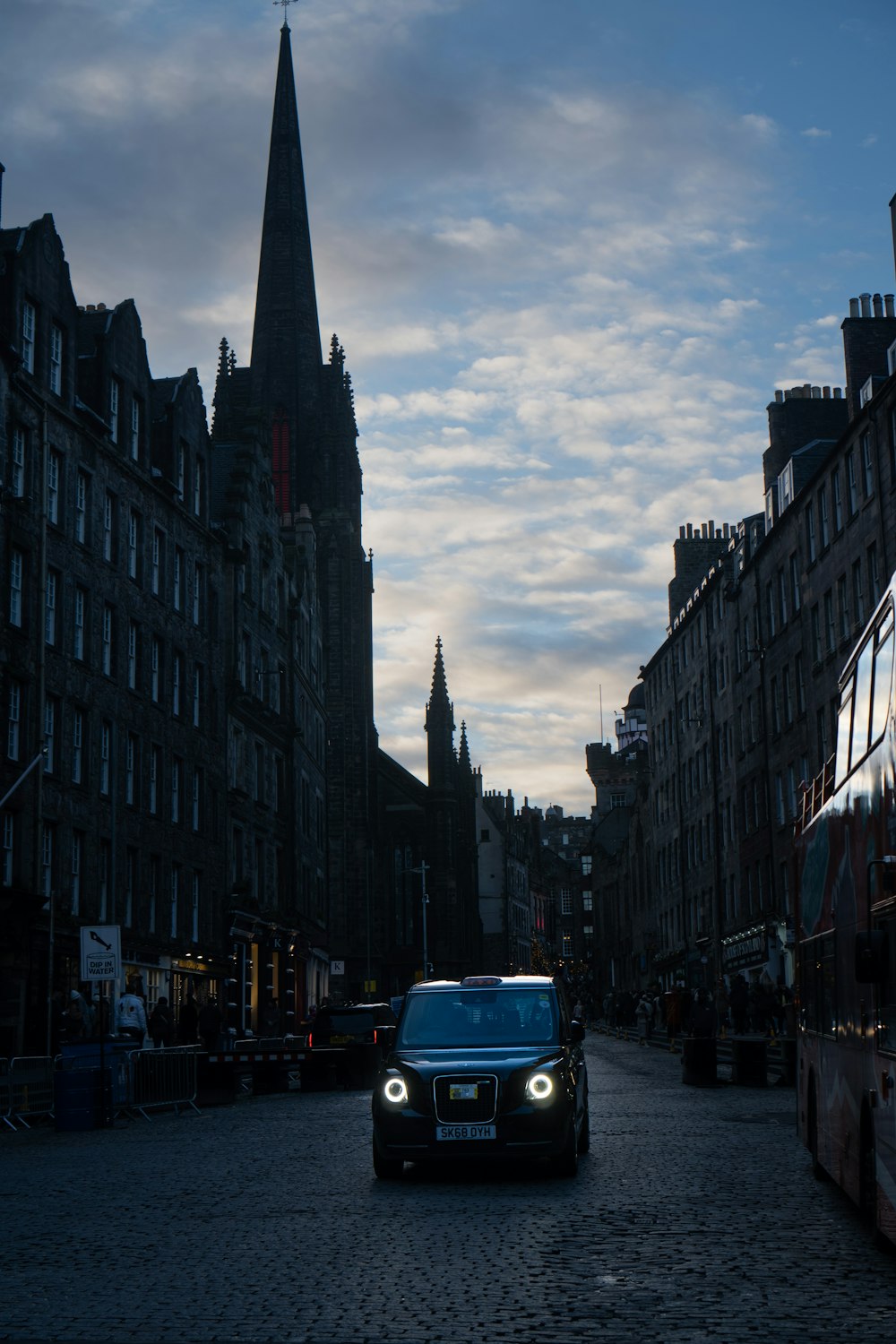 a car driving down a street next to tall buildings