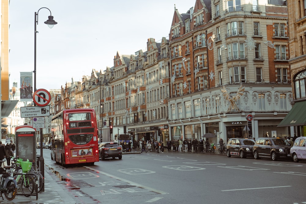 a red double decker bus driving down a street