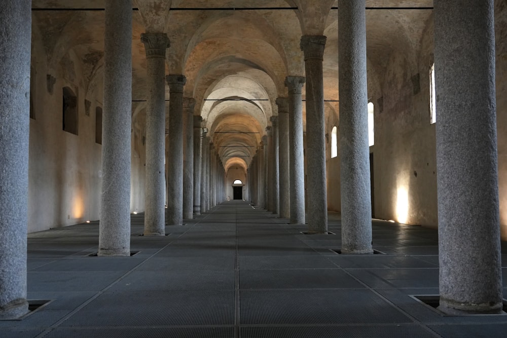 a long hallway with columns and lights on either side