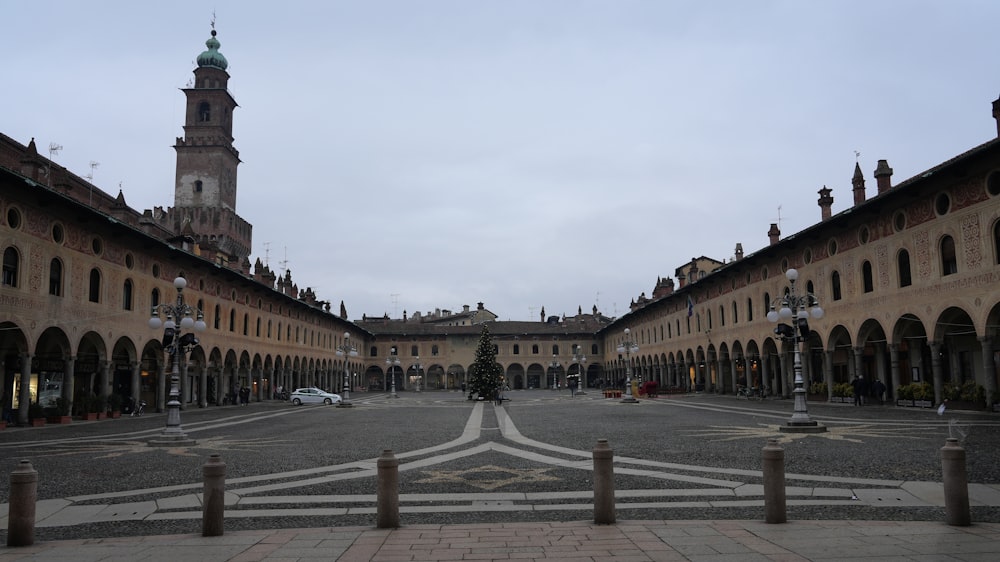 a large courtyard with a clock tower in the background