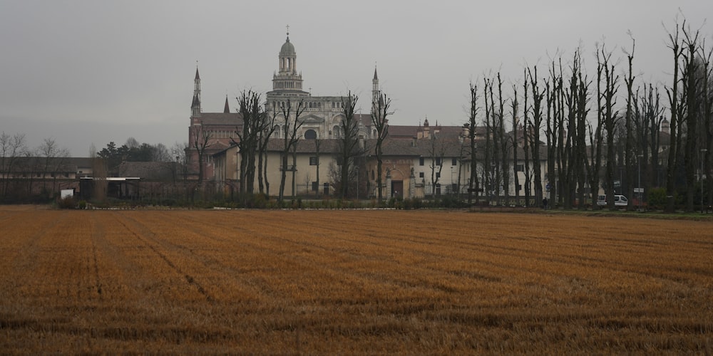 a large building with a clock tower in the middle of a field