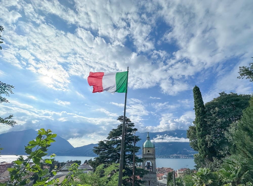 a flag flying in the wind on top of a hill