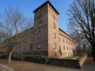 a tall brick building with a clock on the top of it