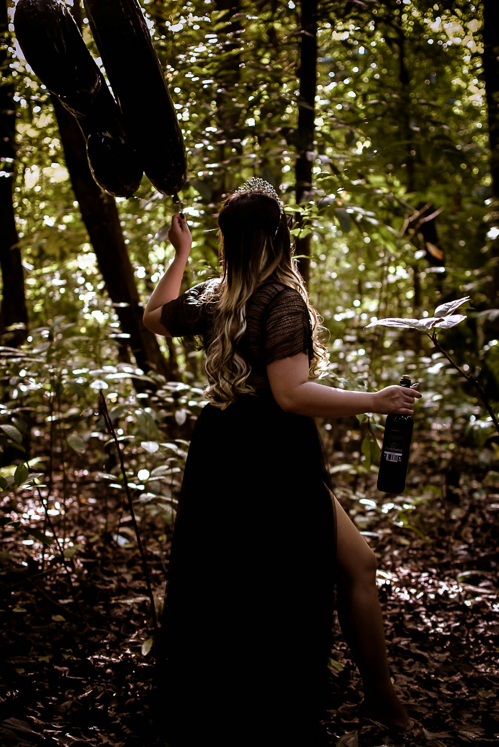 a woman in a black dress in the woods
