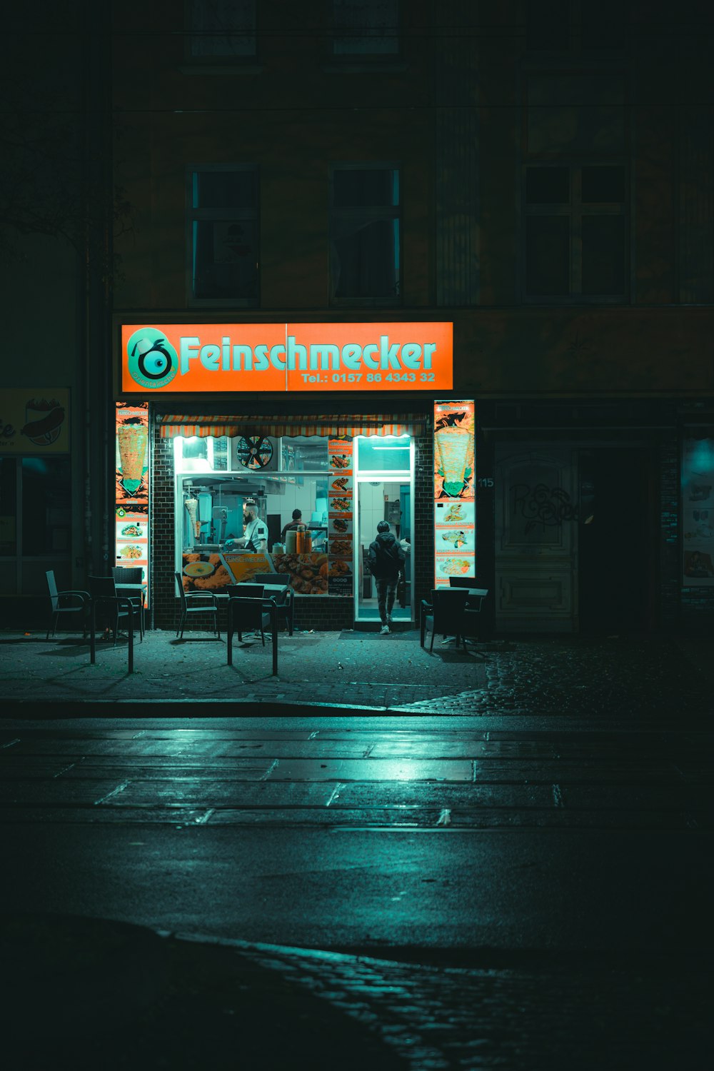 Una strada buia con la facciata di un negozio illuminata di notte