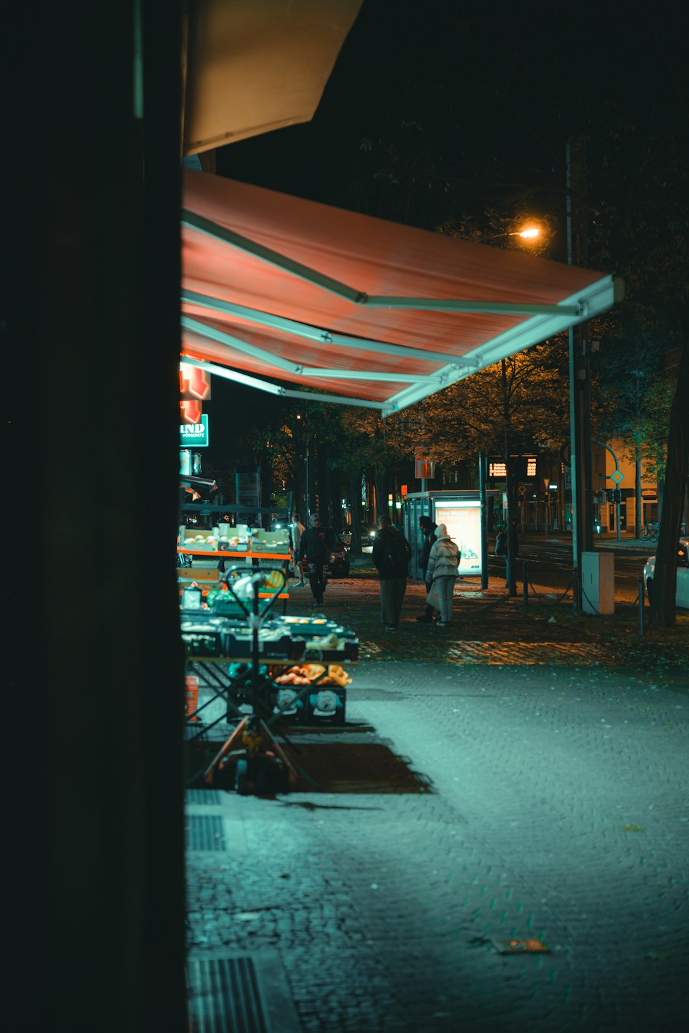 a group of people walking down a street at night