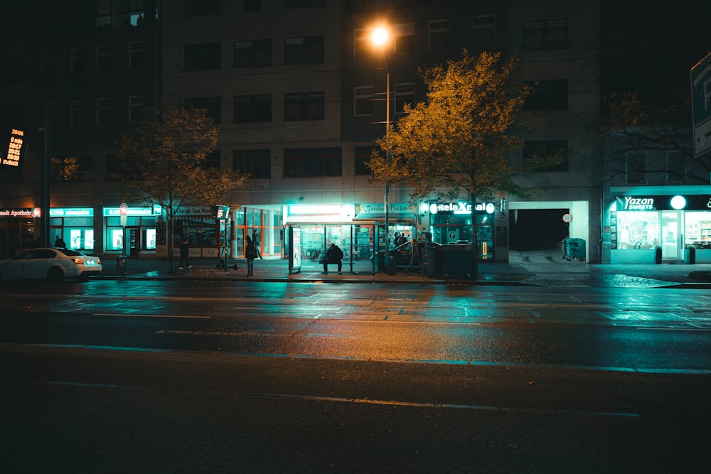 Eine nächtliche Stadtstraße mit Bushaltestelle