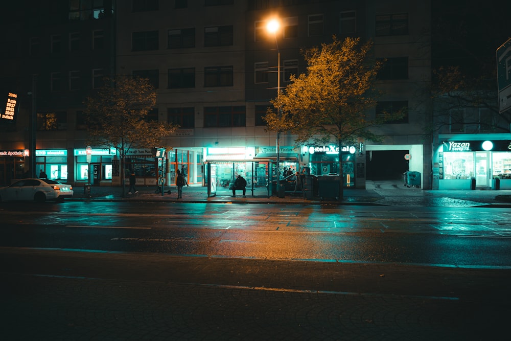 a city street at night with a bus stop