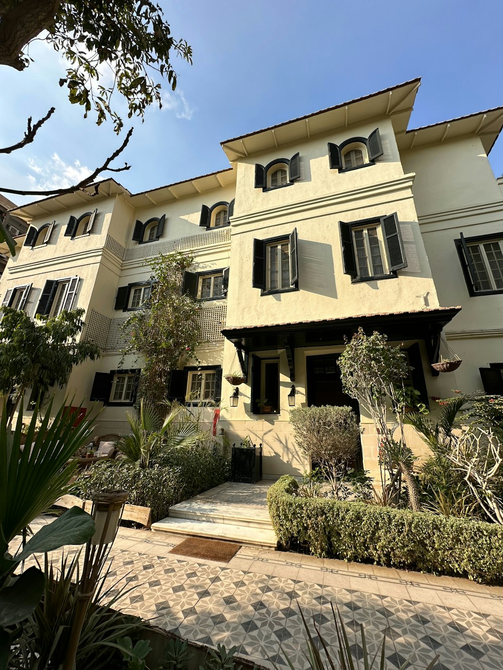 a large white building with many windows and plants