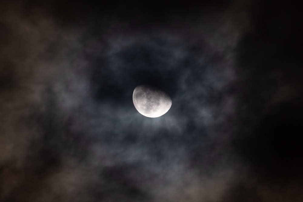the moon is seen through the clouds in the sky