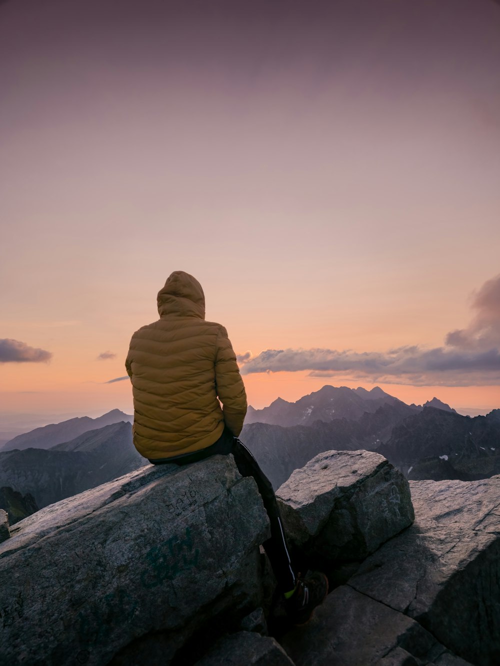 a person sitting on top of a large rock