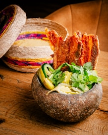 a wooden table topped with a bowl filled with food