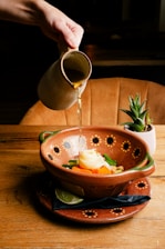 a person pours some liquid into a bowl of food