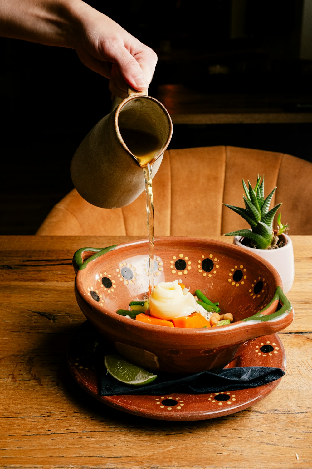 a person pours some liquid into a bowl of food