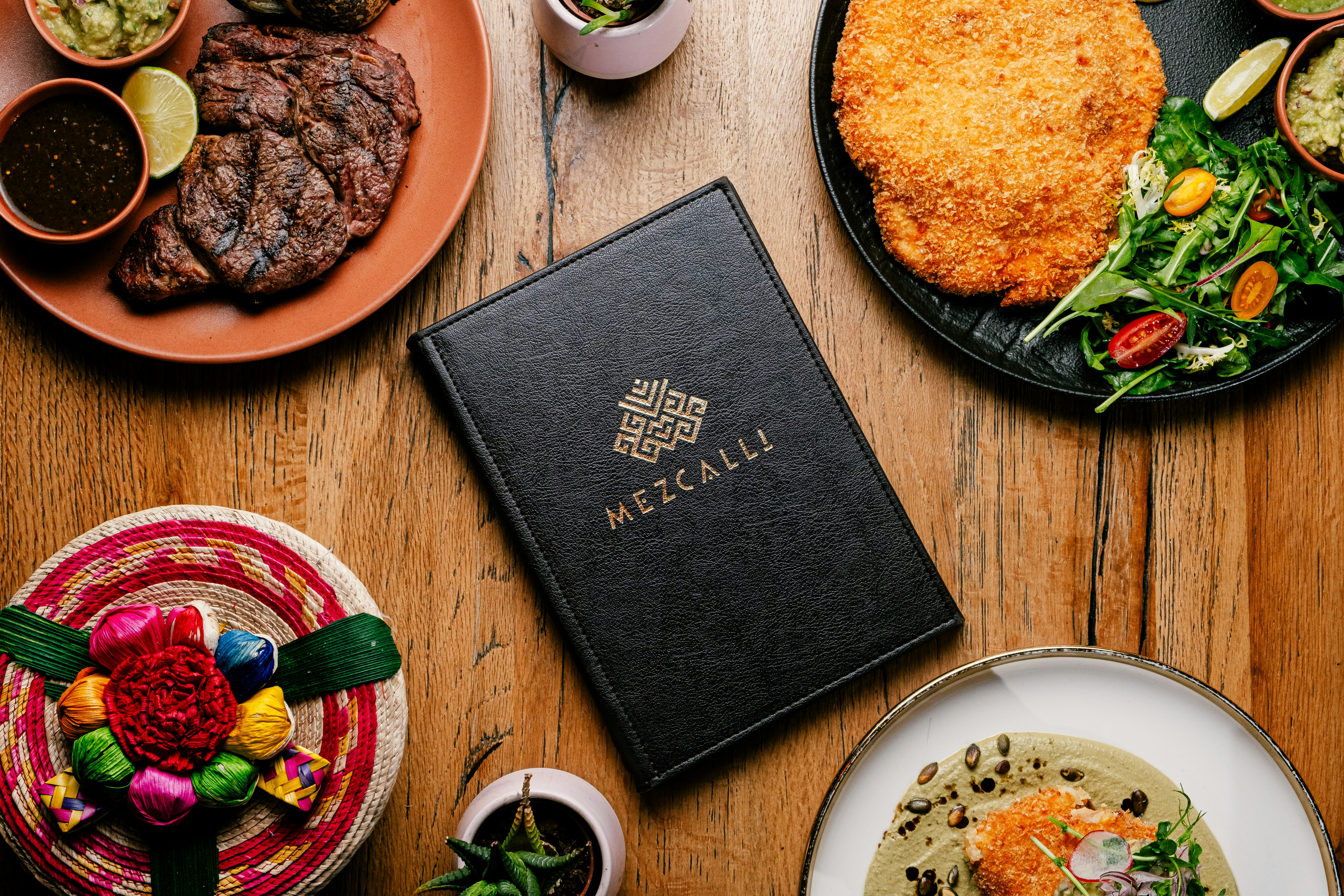 a table topped with plates of food and a menu
