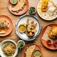 a wooden table topped with plates of food