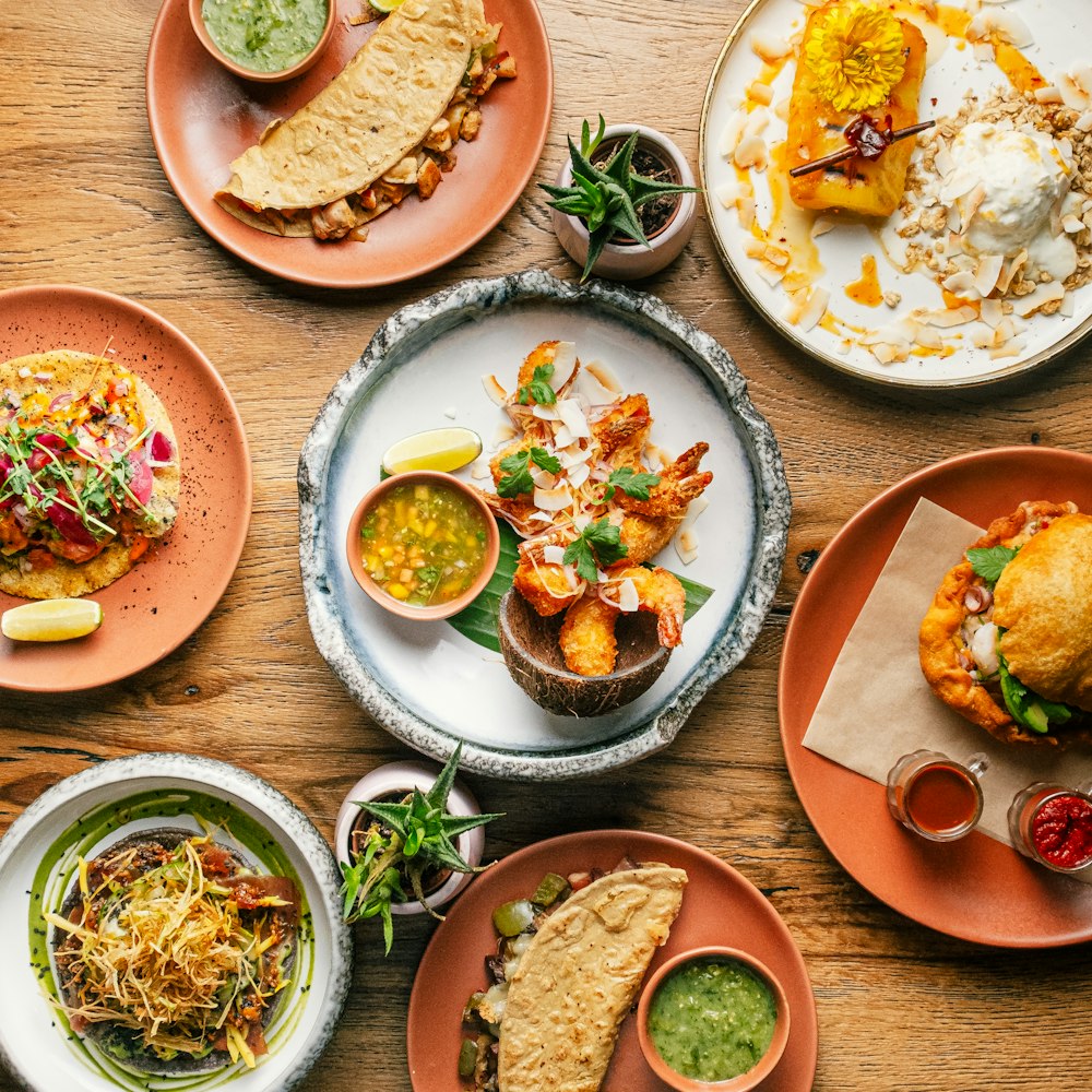 a wooden table topped with plates of food