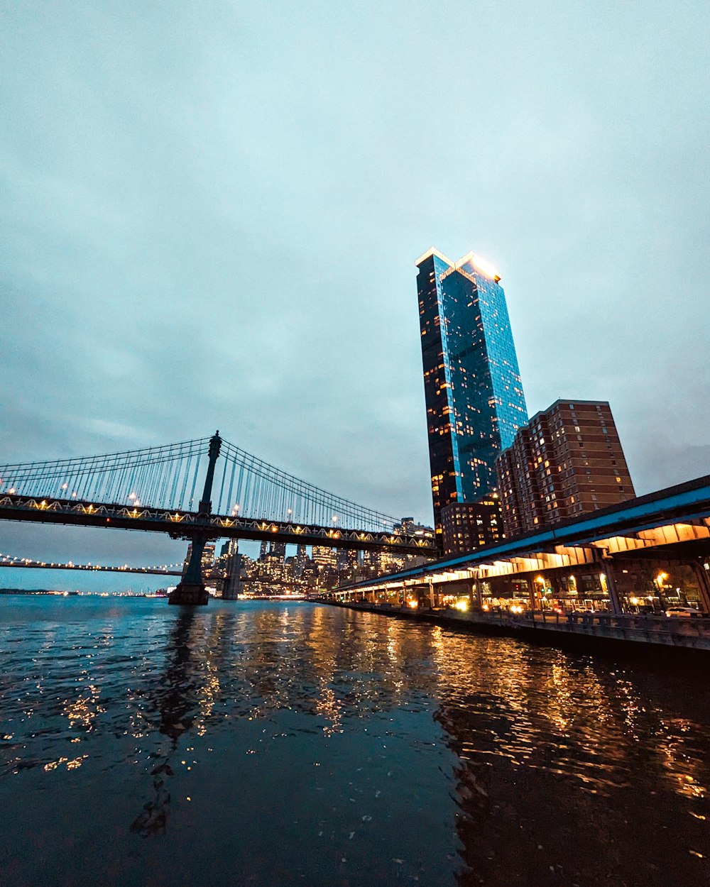 a bridge over a body of water next to a tall building