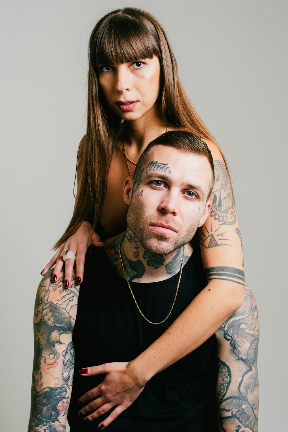 a tattooed man holding a woman in his arms