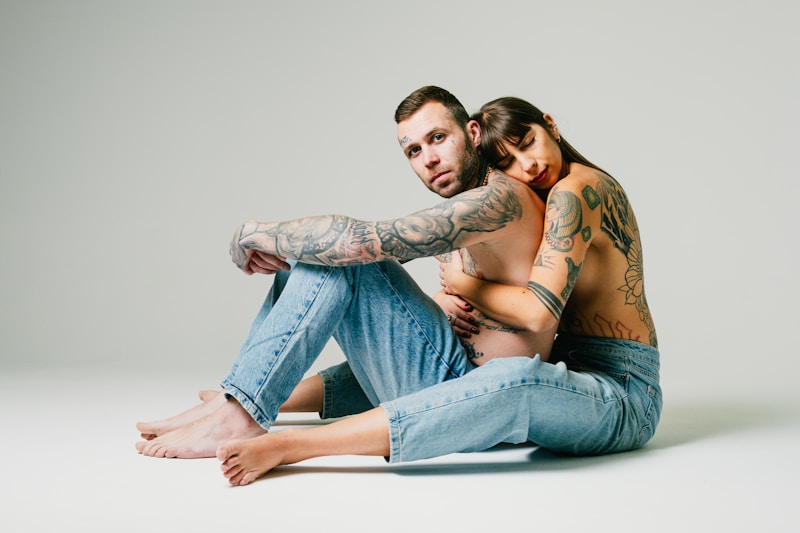 a tattooed man and woman sitting on the floor