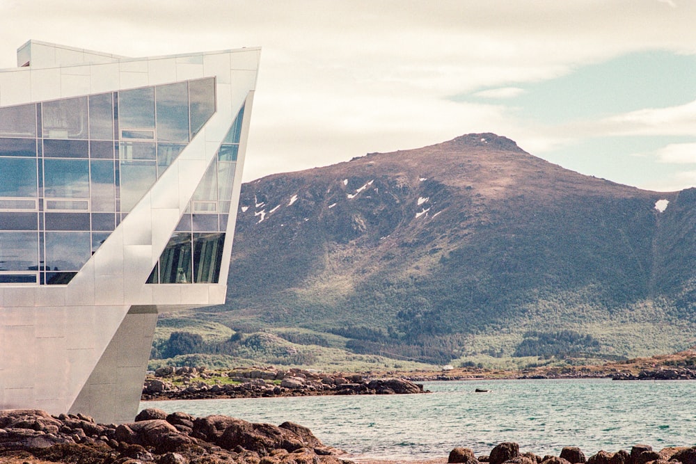 a white building sitting on top of a rocky beach