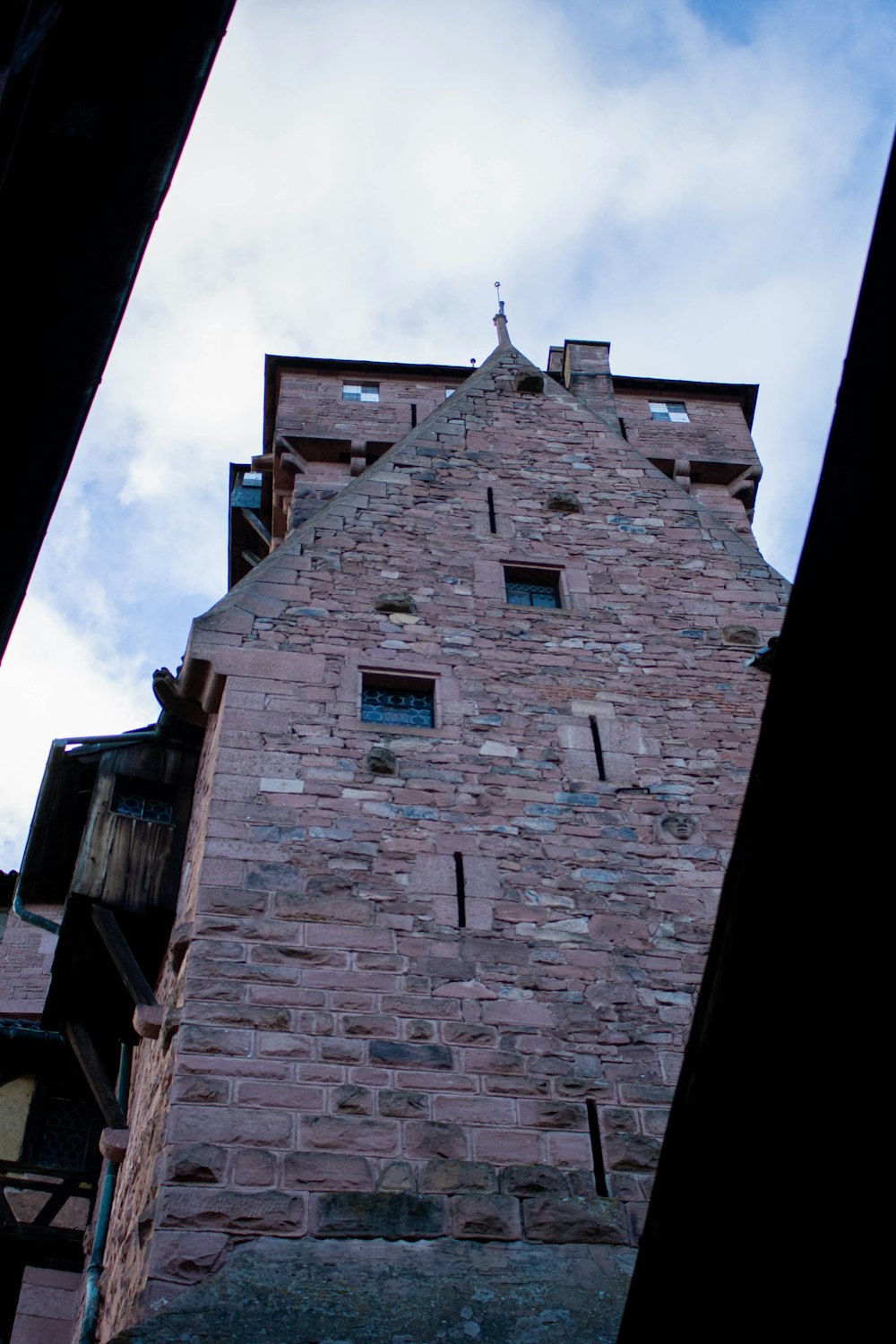 a tall brick building with a clock on it's side