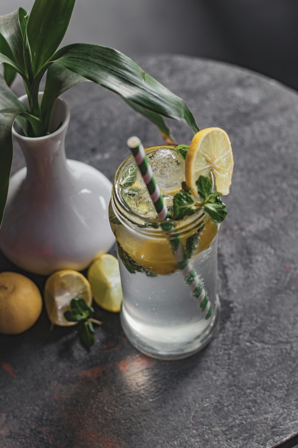 a glass of lemonade with a straw and lemons next to it