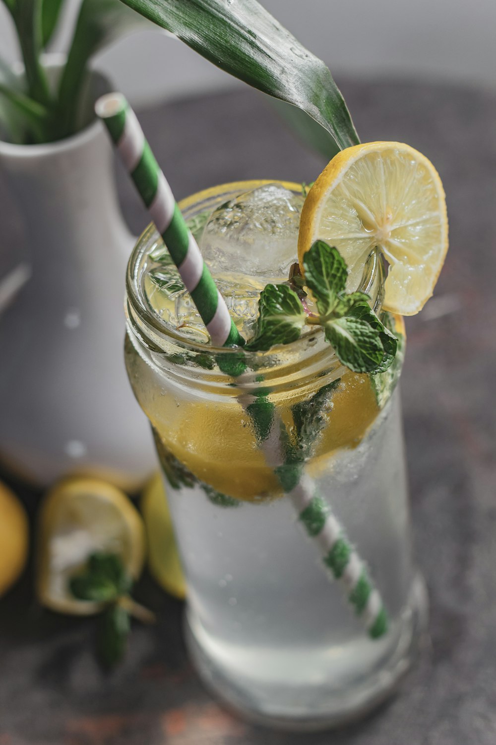 a glass of lemonade with a green and white striped straw