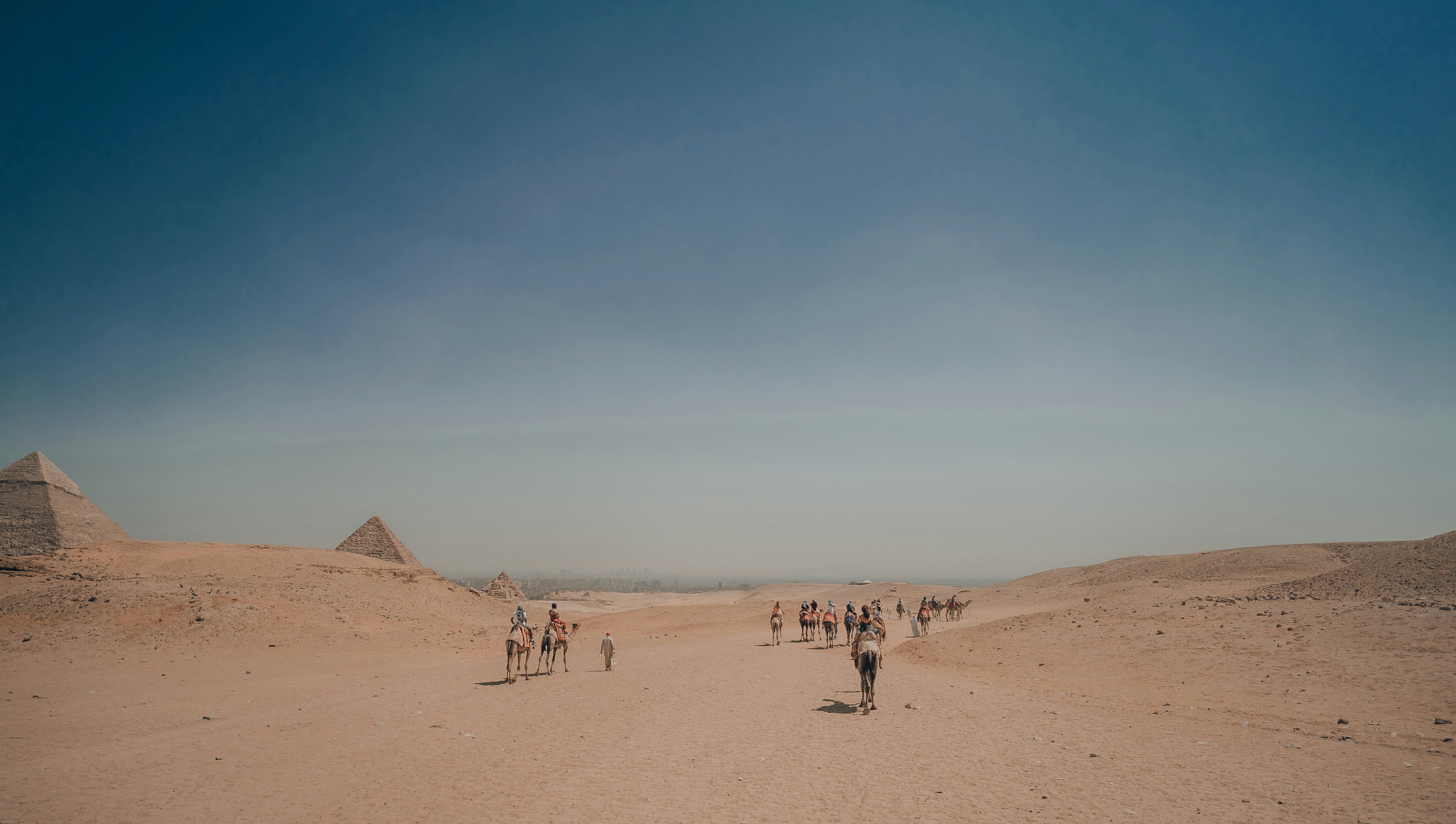 A group of people walking across a sandy field