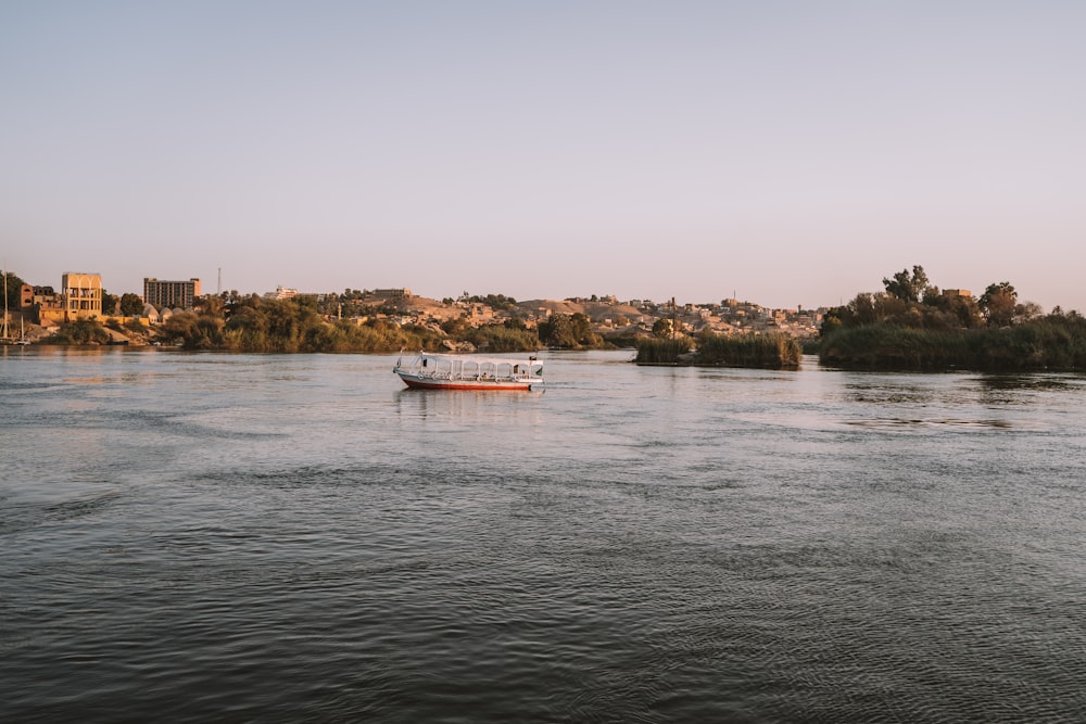 un bateau sur une rivière avec une ville en arrière-plan