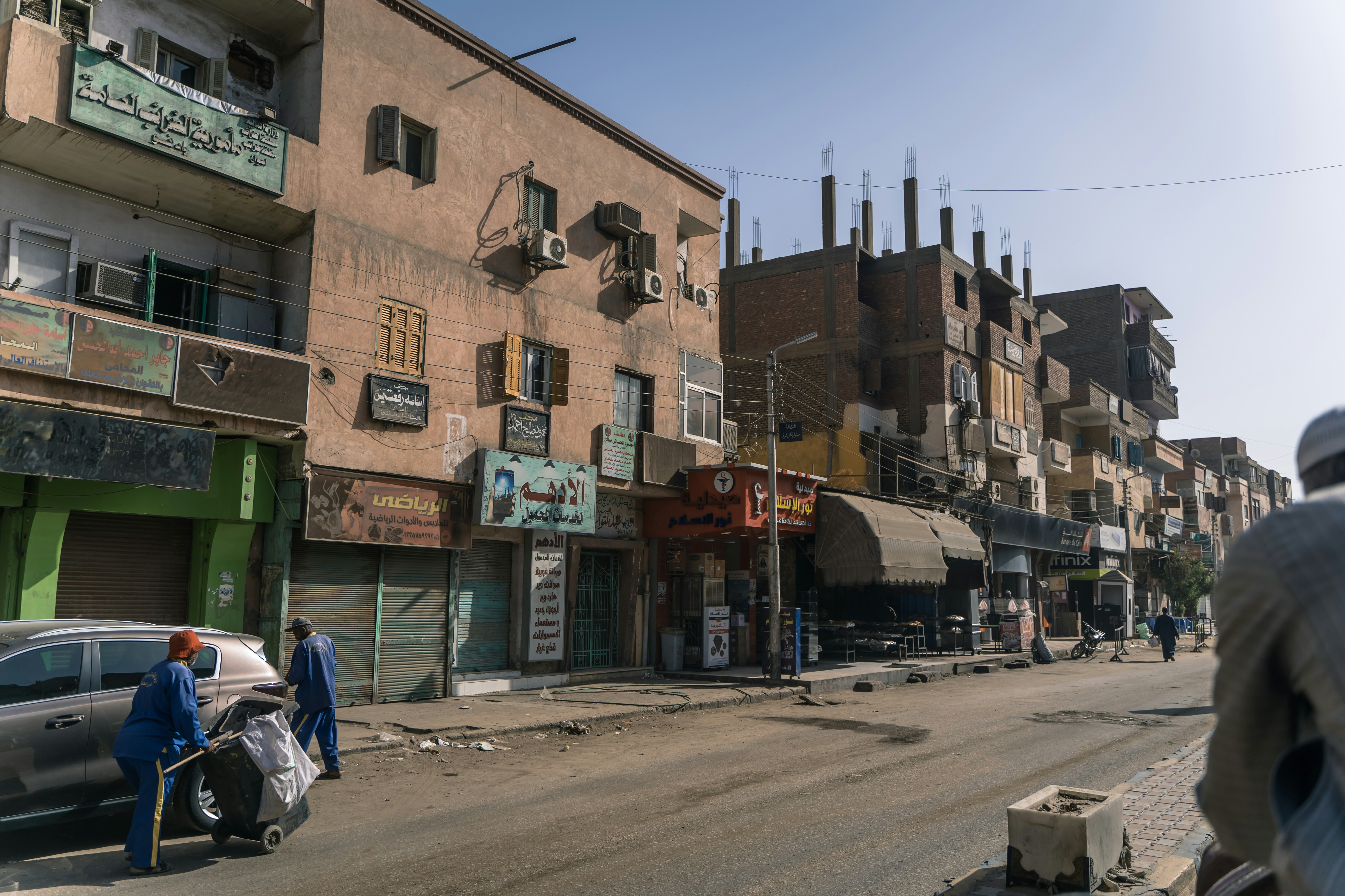 A man pushing a cart down a city street