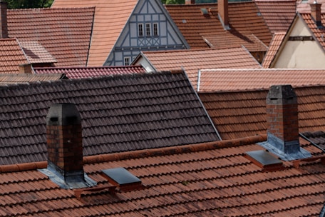 a row of rooftops with a clock tower in the background