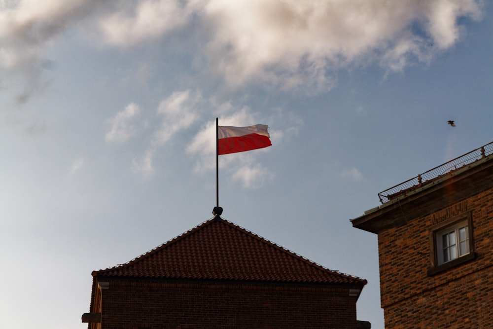a red and white flag on top of a building