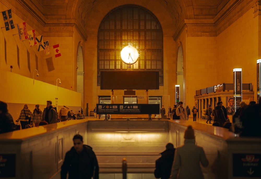 a group of people walking around a train station