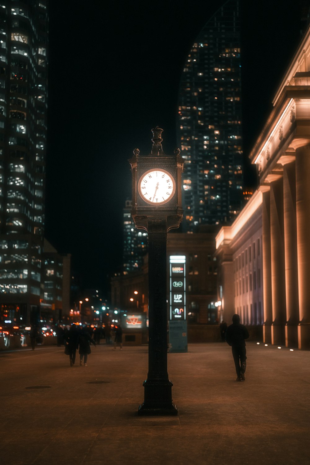 a clock on a pole in the middle of a street