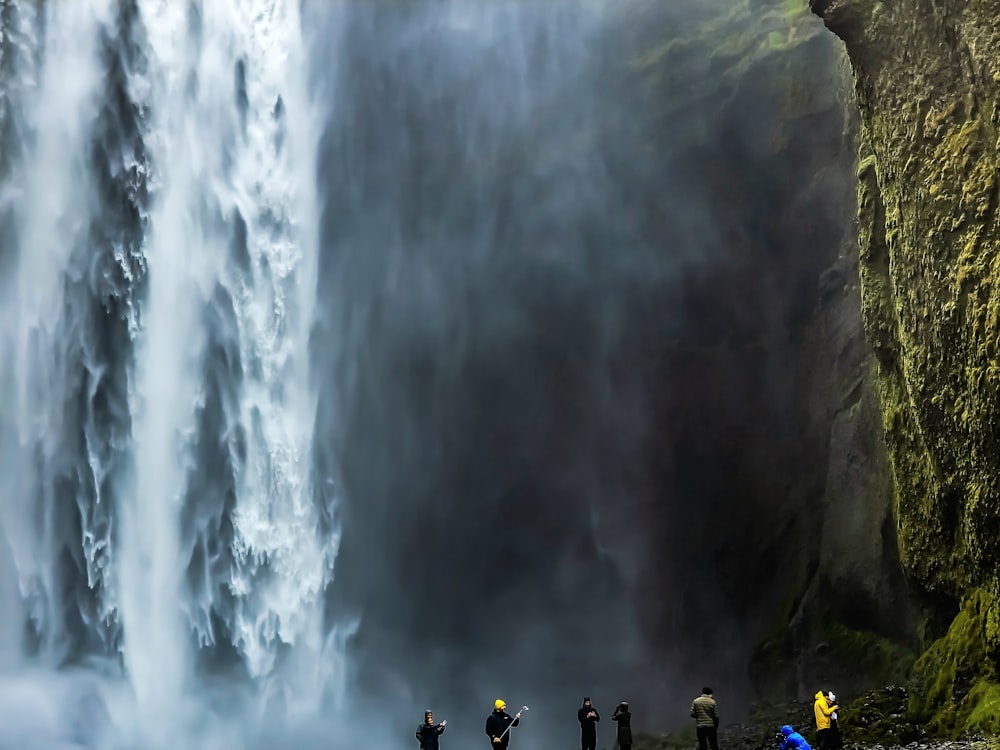 Un grupo de personas de pie frente a una cascada