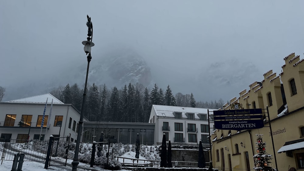 a snowy street with buildings and a mountain in the background