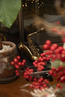 a table topped with a potted plant next to a saxophone