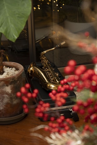 a table topped with a potted plant next to a saxophone