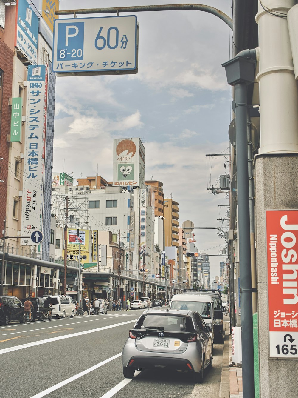 a car driving down a street next to tall buildings