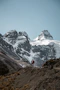 a person standing on a hill with mountains in the background