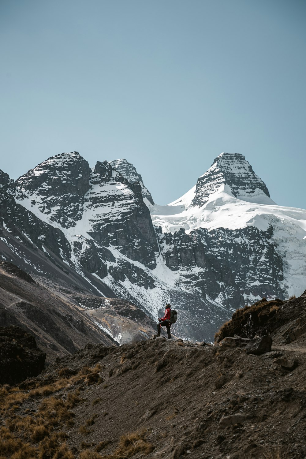 a person standing on a hill with mountains in the background