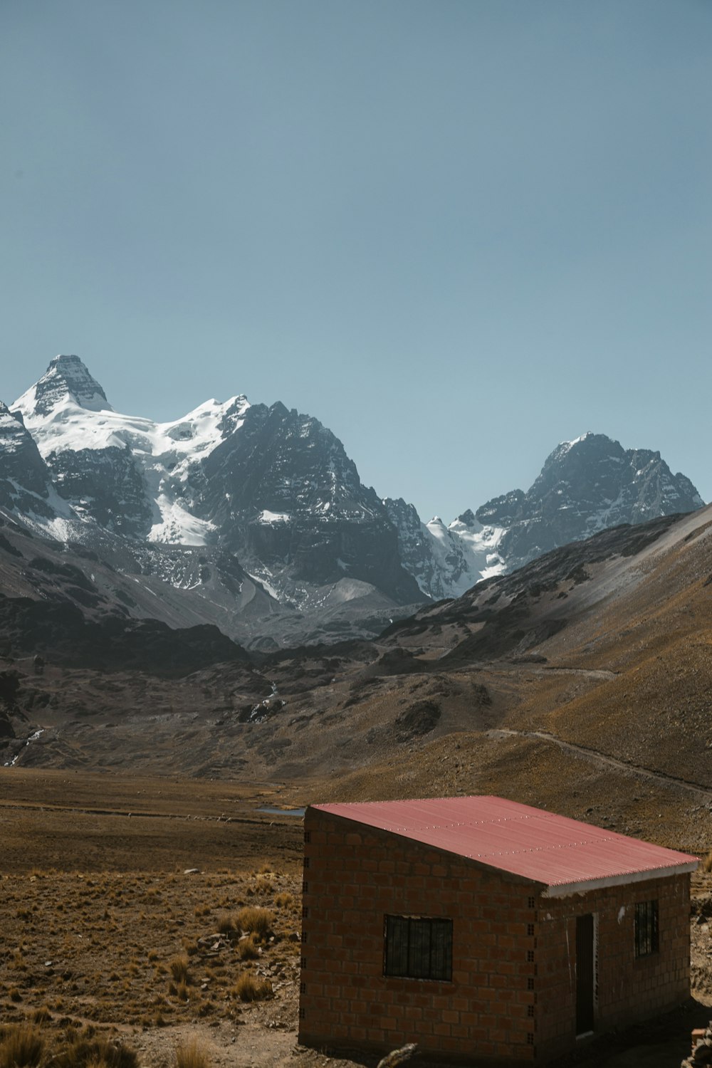a small building in the middle of a mountain range