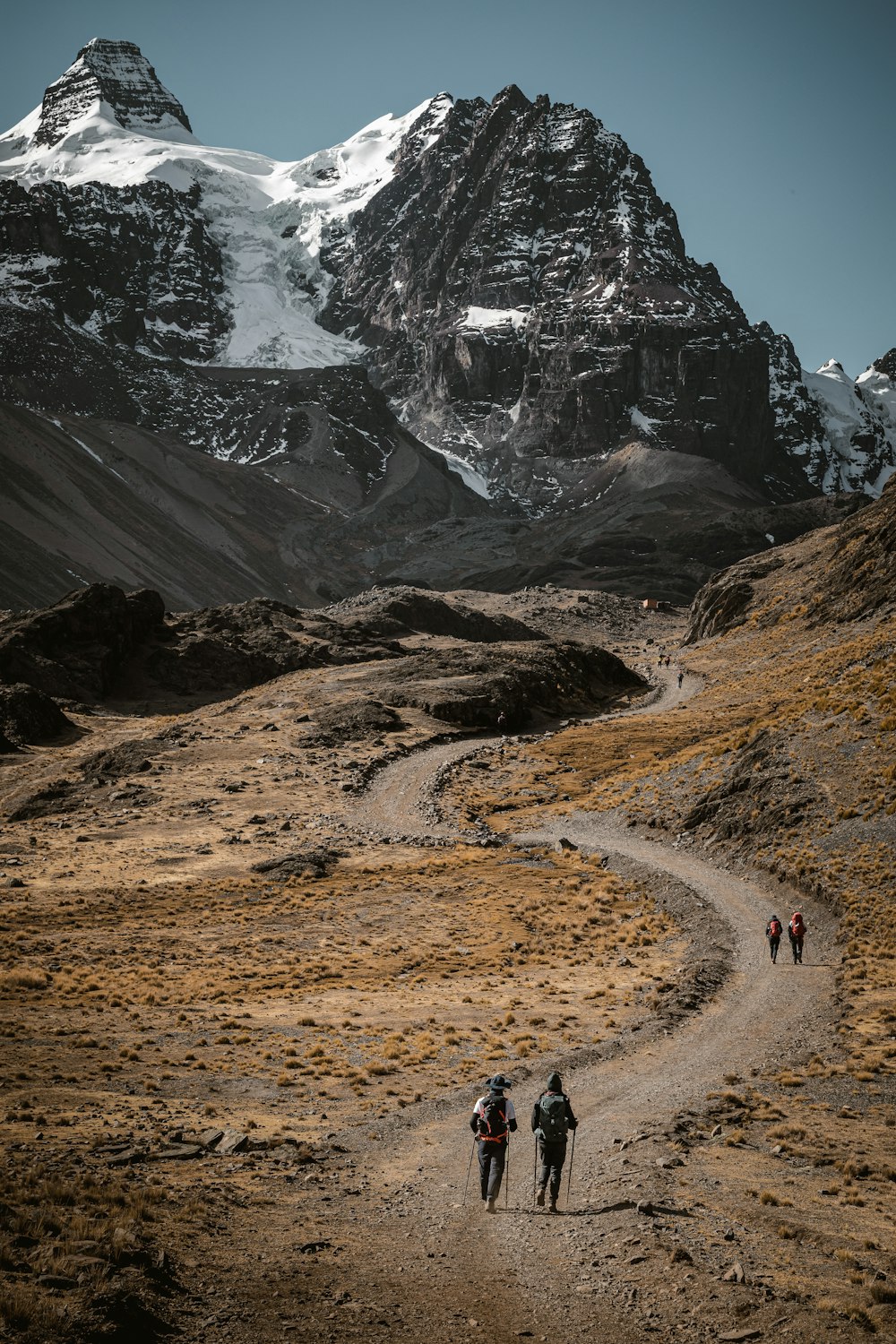 a group of people walking down a dirt road