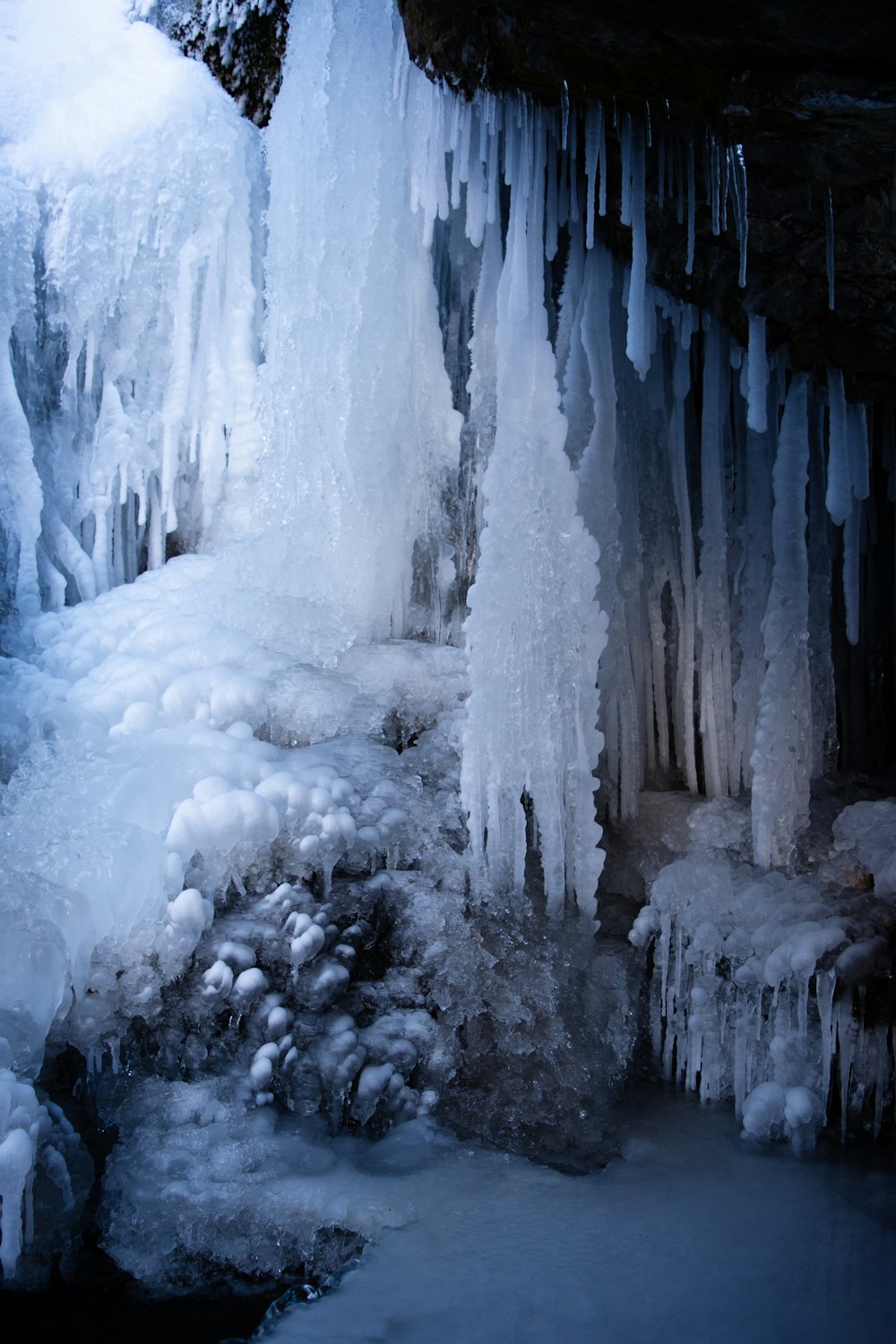 a group of icicles hanging from the side of a cave